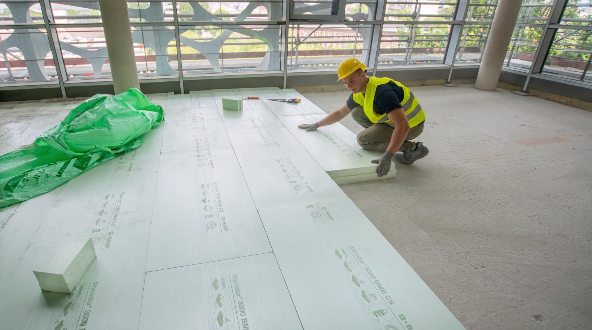 Handwerker verlegt Styrodur auf der Baustelle