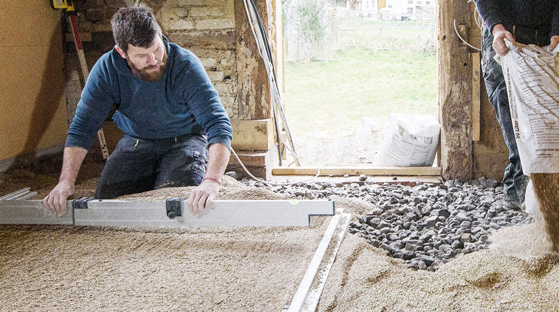 Ein Handwerker beim Glattziehen des Bodens.