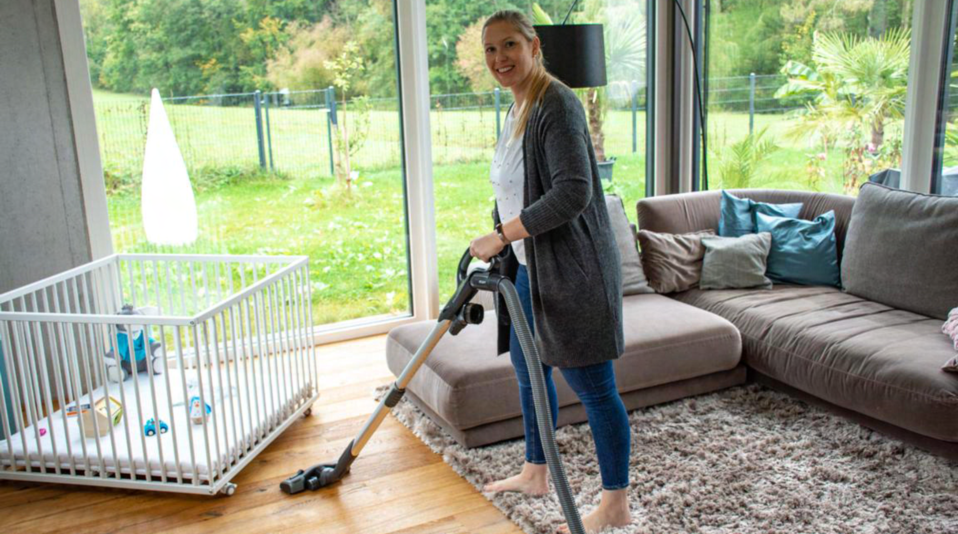 Mutter mit Staubsauger in Wohnzimmer