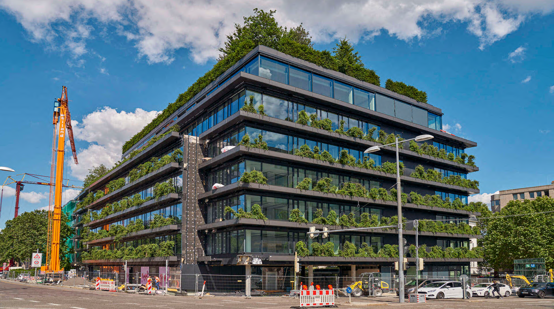 Die Gesamtansicht der Calwer Passage von vorne, das Foto zeigt die mit Pflanzen gespickte Fassade sowie die Straße und den Gehweg..