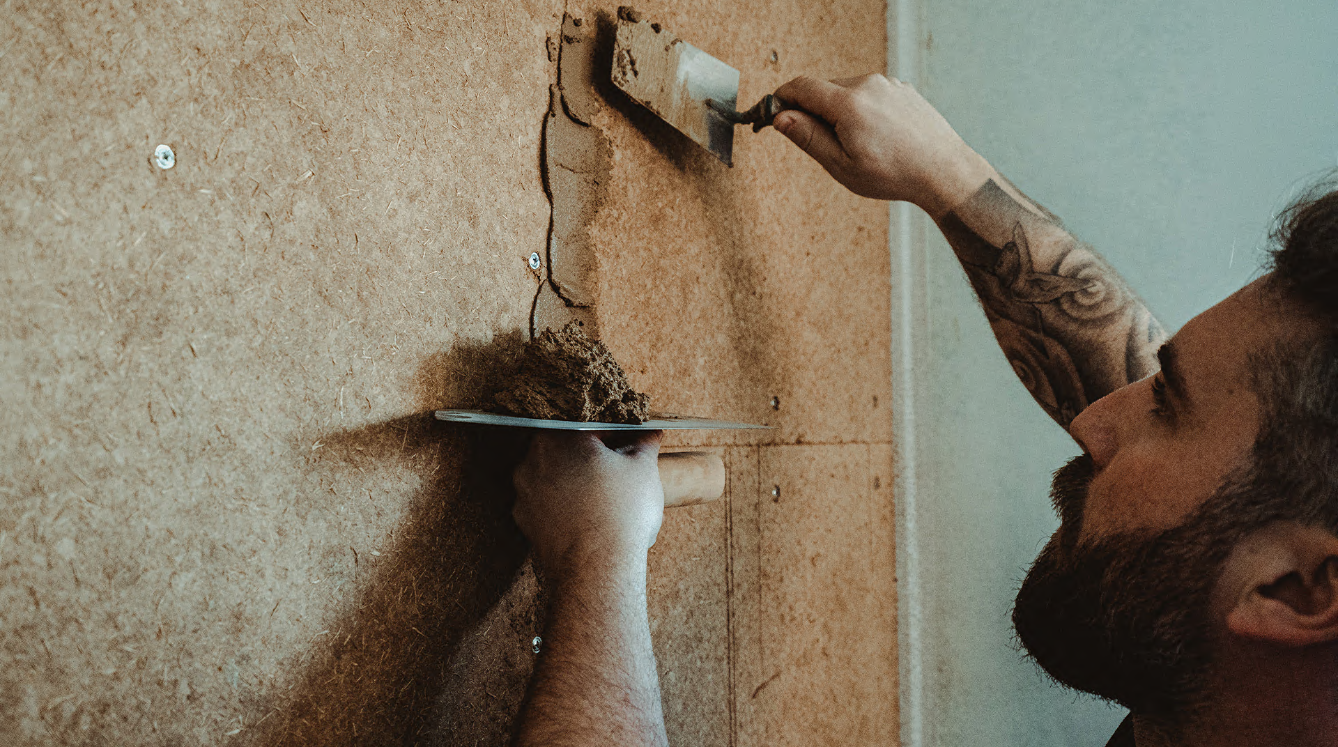 Handwerker beim verputzen mit Lehm