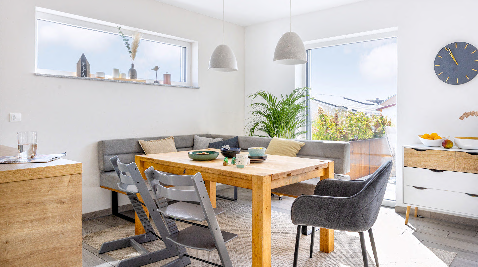 Helles Essbereich mit Eckbank, Tisch und Blick auf den Balkon