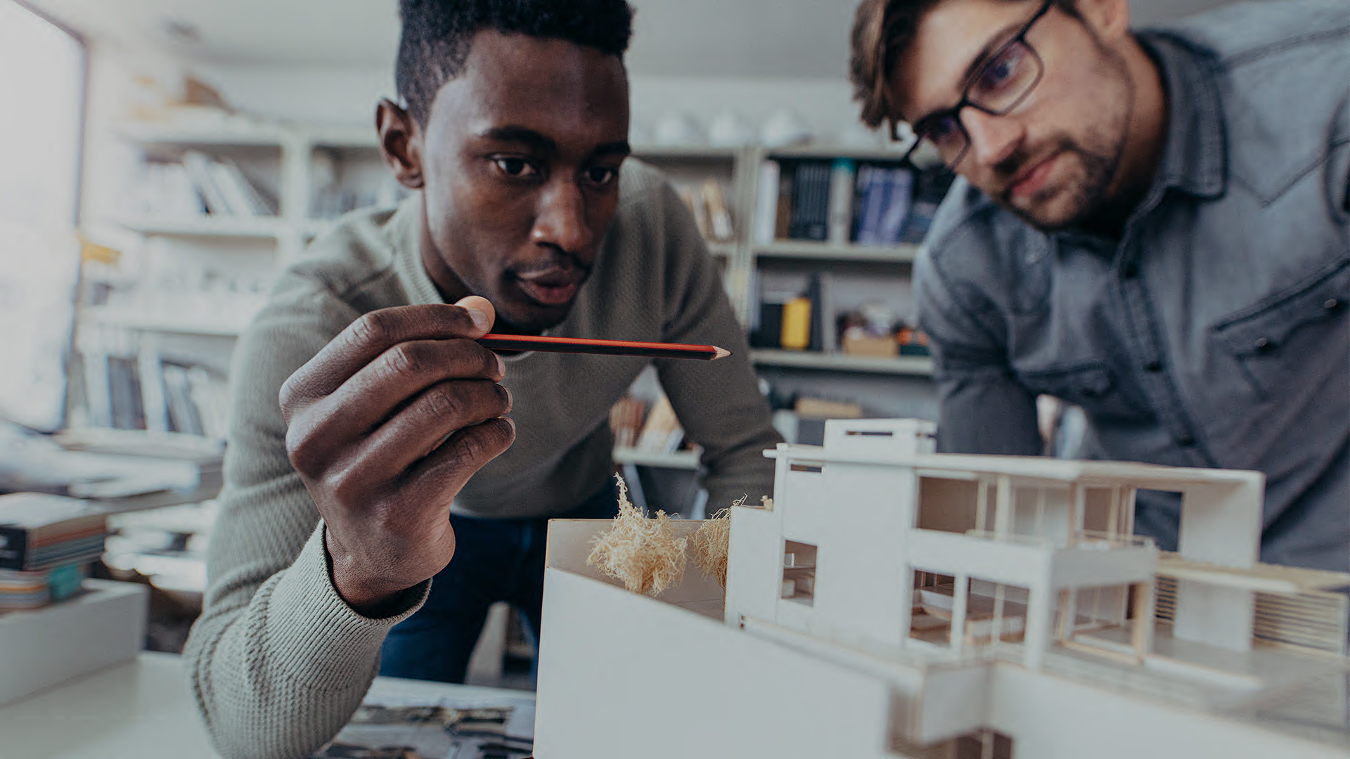 Zwei Architekten sehen sich das Model eines Hauses an