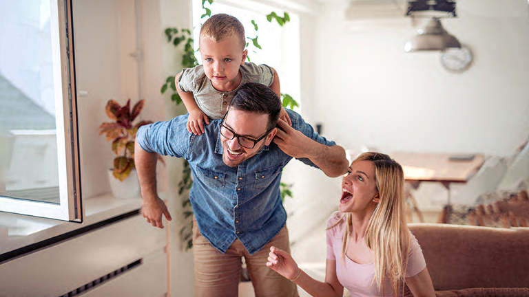 Familie spielt mit kleinem Kind im Wohnzimmer